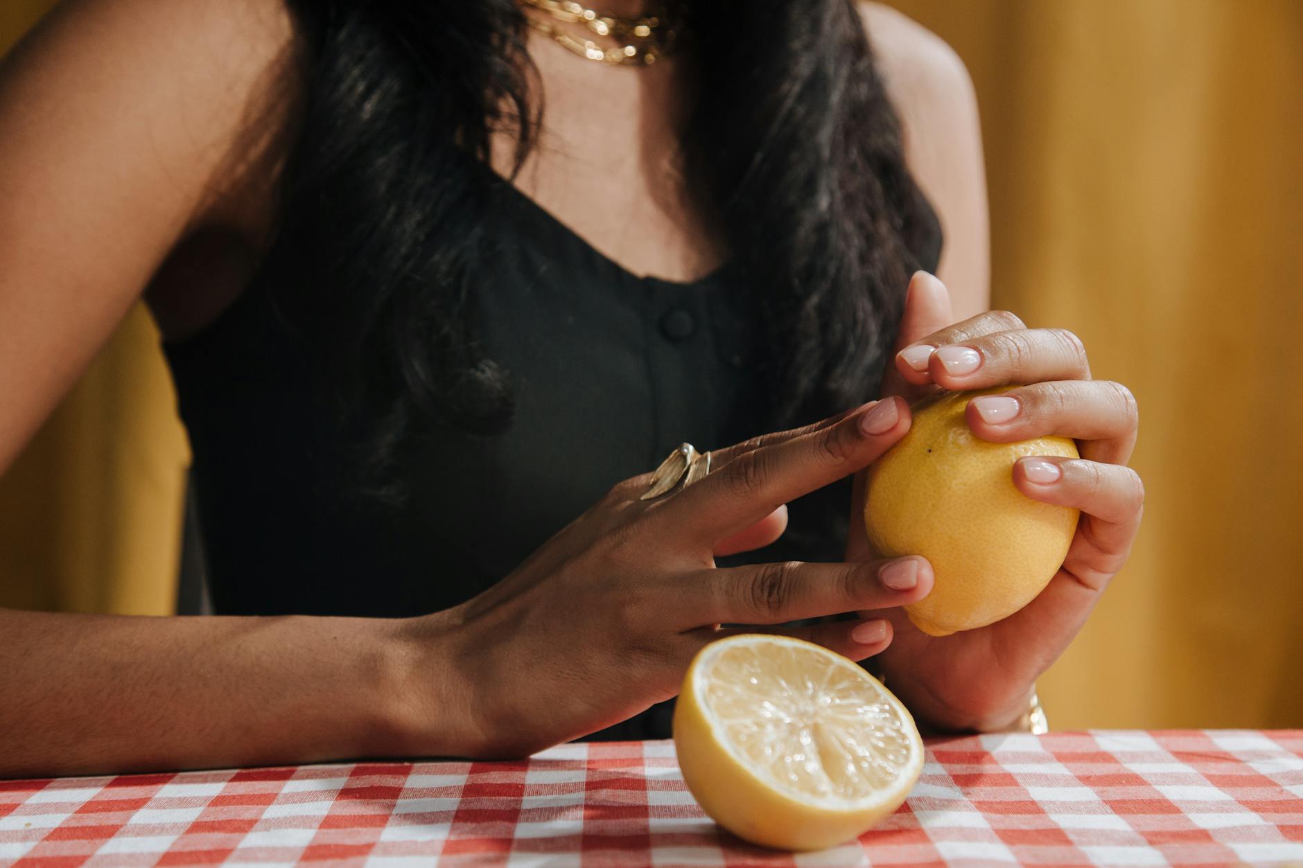 A woman holding a fresh lemon, symbolizing the natural pleasure and simplicity that lemon clitoral vibrators bring back to intimate moments.