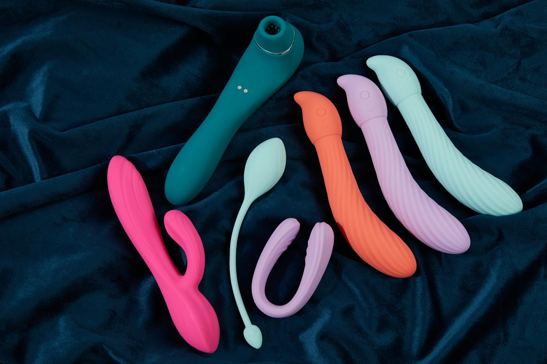 A hand holding a vibrator against a minimalist purple background, demonstrating modern sensuality and self-care